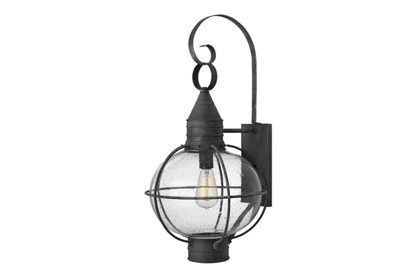 Pictured is a wall light with curved metal work, a caged light, and a weathered appeal.