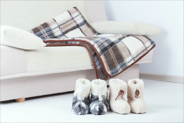 White Couch With Soft Blanket And Little Boots