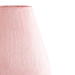A close-up of a soft pink table lamp