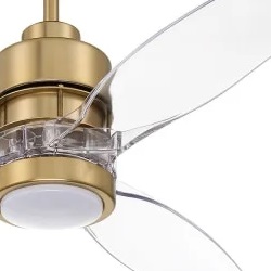 A close-up of a brass ceiling fan with clear blades